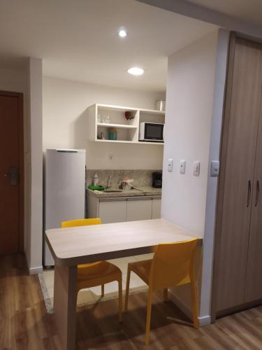 uma cozinha com uma mesa e cadeiras e um frigorífico em Studio Moderno bem localizado em Feira de Santana