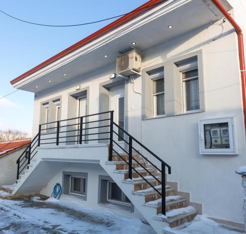 a white building with stairs on the side of it at Stavroula's Houses in Kélla
