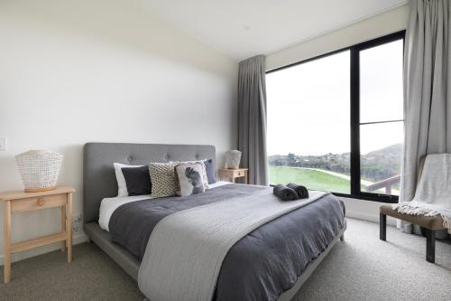 a bedroom with a large bed and a large window at Topdeck at Snelling Beach in Stokes Bay