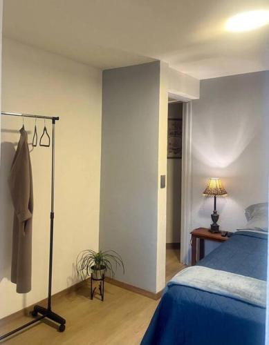 a bedroom with a blue bed and a lamp at Depto. Equipado, 1 Habitación con estacionamiento in Tulancingo