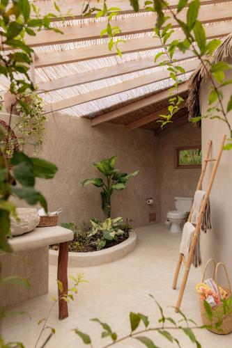 a bathroom with a toilet in a room with plants at La Fragata in Vichayito