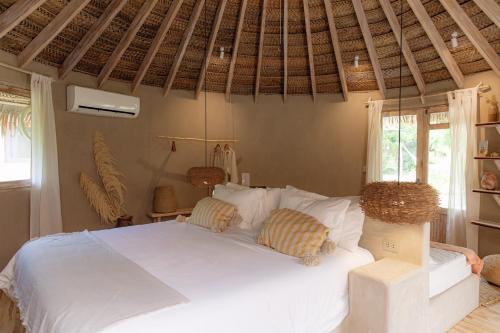 a bedroom with a white bed with two pillows at La Fragata in Vichayito