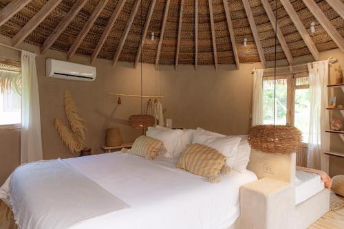 een slaapkamer met een wit bed met 2 kussens bij La Fragata in Vichayito
