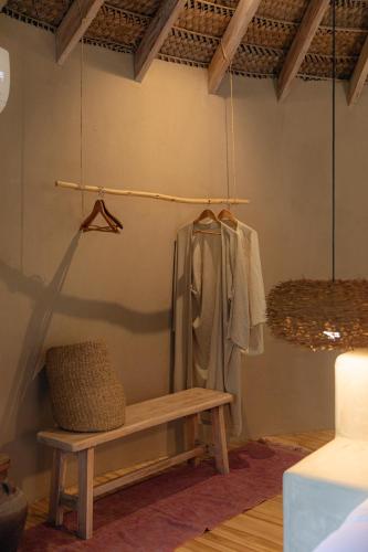 a room with a bench and a coat hanging on a wall at La Fragata in Vichayito