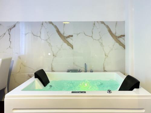 baño con bañera con pared de mármol en EXE NAPOLI STADIUM APARTMENT, en Nápoles
