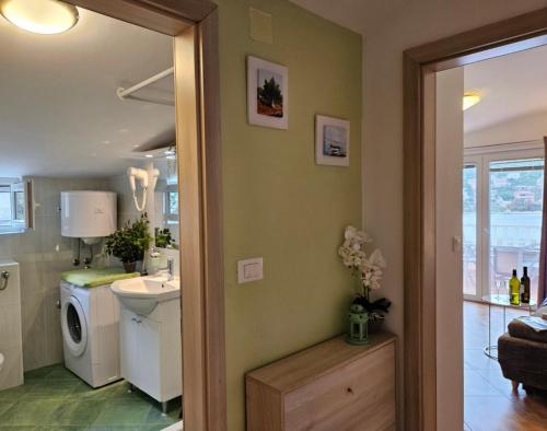 ein Badezimmer mit Waschbecken und Waschmaschine in der Unterkunft Lumare in Grebaštica