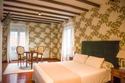 a bedroom with a bed and a table and chairs at Hotel A Casa Do Rio in Padrón