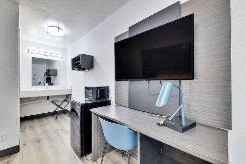 a room with a desk with a flat screen tv at Motel 6-Austin, TX - Airport - South in Austin