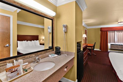 Cette chambre comprend un lavabo et un grand miroir. dans l'établissement Best Western Willits Inn, à Willits