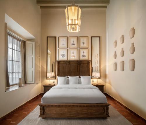 a bedroom with a bed and two lamps and a chandelier at Casa Alondra in Morelia