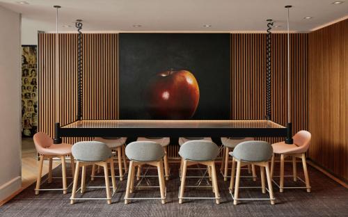 an apple on a wall above a table with chairs at Hotel Zena Washington DC in Washington