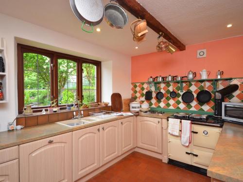 a large kitchen with white cabinets and a sink at 3 Bed in Dulverton RDOOR in Exton