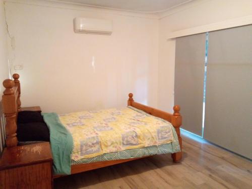 1 dormitorio con 1 cama y puerta corredera de cristal en Homestay upon Kenwick Station, en Perth