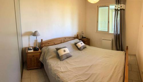 une chambre avec un lit avec deux oreillers dessus dans l'établissement Résidence Olivier - APPARTEMENT FRONT DE MER DANS DOMAINE AVEC PISCINE MAE-8764, à Six-Fours-les-Plages