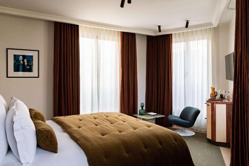 a hotel room with a large bed and a chair at Hotel Florida Paris in Paris