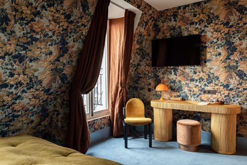 a bedroom with a bed and a desk and a television at Hotel Florida Paris in Paris