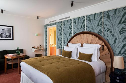 - une chambre avec un grand lit et du papier peint vert et blanc dans l'établissement Hotel Florida Paris, à Paris