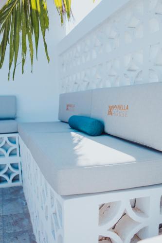 a white bed with a blue pillow on it at Hermosa vista al mar desde rooftop y a pocos metros de mar in Cartagena de Indias