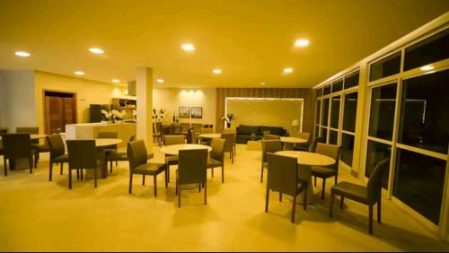 a restaurant with tables and chairs in a room at Apartamento encantador in Ilhéus