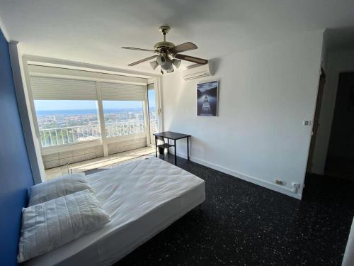 une chambre avec un lit et un ventilateur de plafond dans l'établissement Résidence Rouviere - Grand appartement Vue Mer Budget Maitrisé MAE-9664, à Marseille
