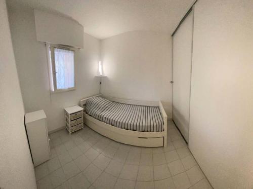 une chambre avec un lit dans une pièce avec une fenêtre dans l'établissement Résidence Morieres B - Super appartement 4 couchages vue mer MAE-0044, à Six-Fours-les-Plages