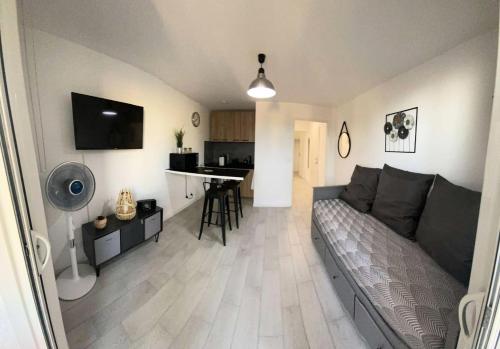 un salon avec un canapé et une cuisine dans l'établissement Résidence Cap Vert - Appartement neuf de standing 4 couchages à Six Fours Les Plages MAE-9914, à Six-Fours-les-Plages
