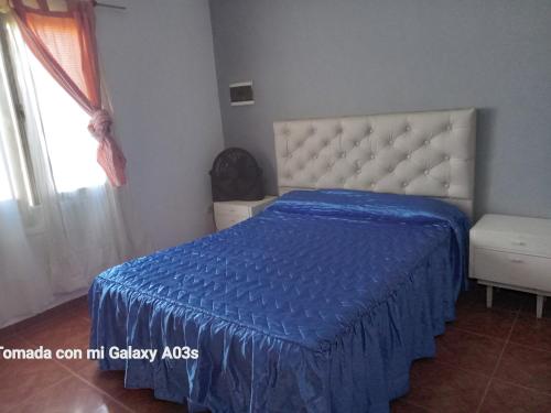 una camera con letto e piumone blu di Residencia Marta a Colonia Caroya
