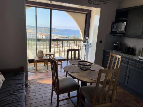 cocina con mesa y sillas y ventana grande en Résidence Jardin D'azur - 2 Pièces pour 4 Personnes 084, en Six-Fours-les-Plages