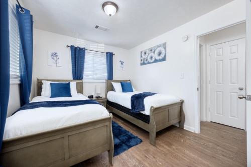 2 camas en un dormitorio con cortinas azules en Southern Charm, en Columbus