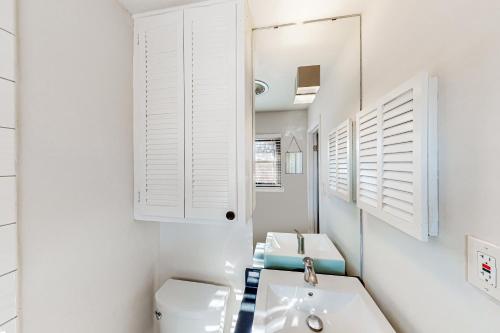 biała łazienka z umywalką i toaletą w obiekcie Mid-Century Memories w mieście Lubbock