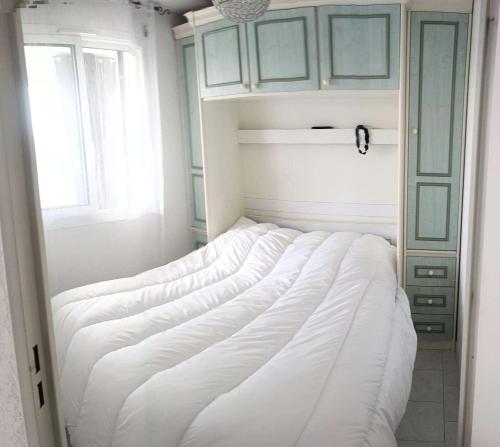 un grand lit blanc dans une chambre avec une fenêtre dans l'établissement Résidence Pinedes Aryana - Joli appartement climatisé dans domaine avec piscine MAE-5614, à Six-Fours-les-Plages