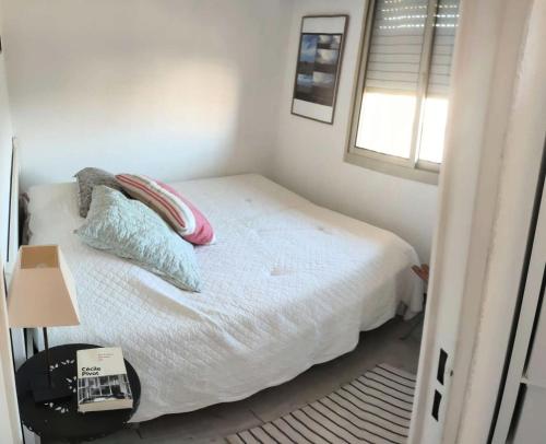 een slaapkamer met een bed met kussens en een raam bij Résidence Tartane - 2 Pièces pour 6 Personnes 674 in Six-Fours-les-Plages
