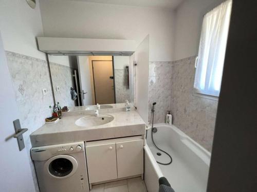 La salle de bains est pourvue d'un lavabo, d'une baignoire et d'un lave-linge. dans l'établissement Résidence Palmiers - Appartement 6 couchages dans un domaine arboré MAE-2854, à Six-Fours-les-Plages