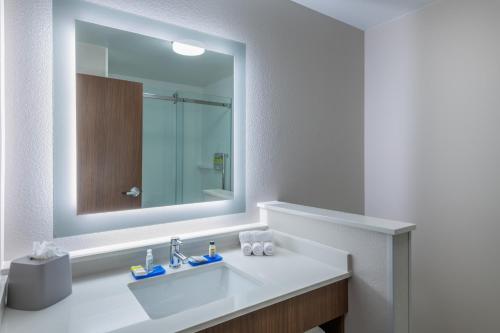 a white bathroom with a sink and a mirror at Holiday Inn Express & Suites - Colorado Springs South I-25 by IHG in Colorado Springs