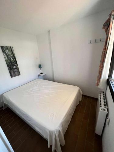 une chambre avec un lit blanc et une fenêtre dans l'établissement Résidence Jardins D Azur B - T2 dans une résidence avec piscine dans le domaine de la Coudoulière MAE-1044, à Six-Fours-les-Plages