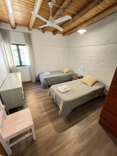 - une chambre avec 2 lits et un ventilateur de plafond dans l'établissement Alojamiento La Casita de Lunlunta, Maipú, Mendoza, à Maipú