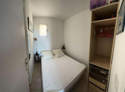 - une petite chambre avec un lit et une étagère dans l'établissement Résidence Grand Large - Appartement T3 remis a neuf MAE-1034, à Six-Fours-les-Plages