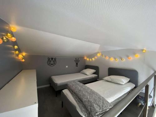 a room with two beds and lights on the ceiling at Résidence Tozza Alta - Pièces 424 in Sari Solenzara