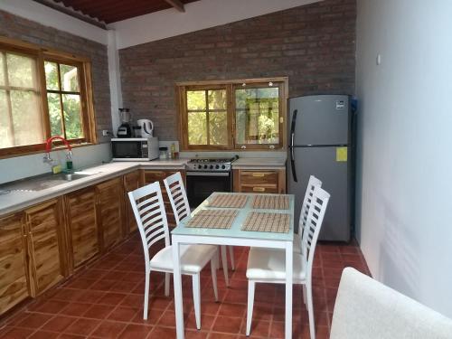 eine Küche mit einem Tisch und Stühlen sowie einem Kühlschrank in der Unterkunft Nueva Tierra, Ayampe in Las Tunas