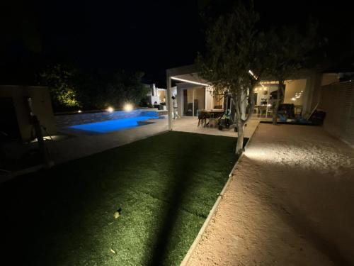 een achtertuin 's nachts met een zwembad en een boom bij Résidence La Batisde - Maisons & Villas pour 8 Personnes 314 in Six-Fours-les-Plages