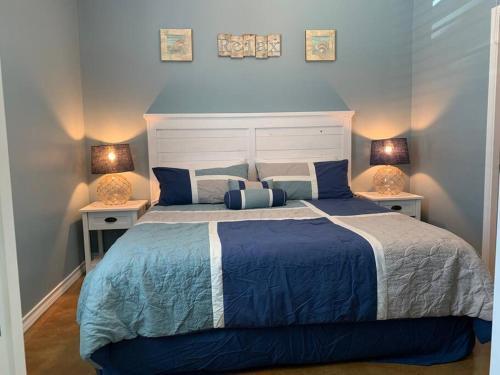 um quarto com uma cama azul e branca com 2 candeeiros em 2 Master Suites & 2 Pools- 1 story near the Beach em Port Aransas