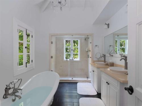 a white bathroom with two sinks and a tub at Sugar Beach, A Viceroy Resort in Soufrière