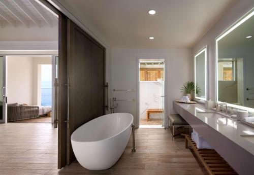 a bathroom with a large tub and two sinks at Sugar Beach, A Viceroy Resort in Soufrière