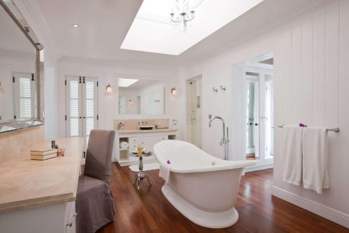 a large white bathroom with a tub and a sink at Sugar Beach, A Viceroy Resort in Soufrière