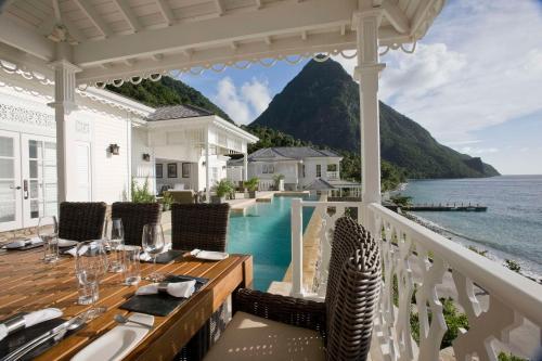 a porch with a table and a view of the water at Sugar Beach, A Viceroy Resort in Soufrière