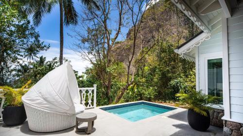 a patio with a swimming pool and a chair at Sugar Beach, A Viceroy Resort in Soufrière