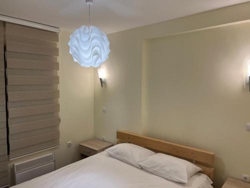 um quarto com uma cama e um candeeiro em Vila Zvončica Apartman Z12 em Kopaonik