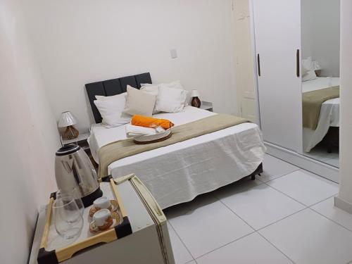 a white bedroom with a bed and a mirror at #PARADISE SUITES - TATUAPÉ in Sao Paulo