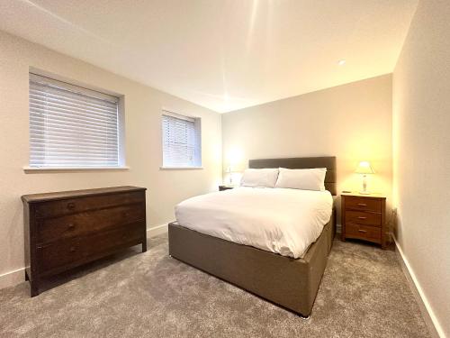 a bedroom with a bed and a dresser and a window at Modern 2 bedroom property with quirky décor in Chilcompton