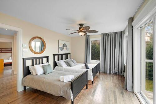 una camera con 2 letti e un ventilatore a soffitto di *NEW* Stunning Waterfront Bright Chalet with Spa a Saint-Calixte